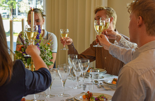Folk ved et restaurantbord skåler. Bilde.
