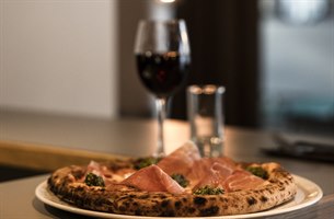 En pizza og et glass vin. Bilde.