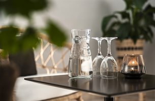 En flaske vann og to glass. Bilde.