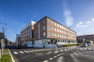 Hotell eksteriør på dagen. Bilde.