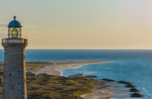 Grey Lighthouse ved vakker strand i Skagen. Bilde.